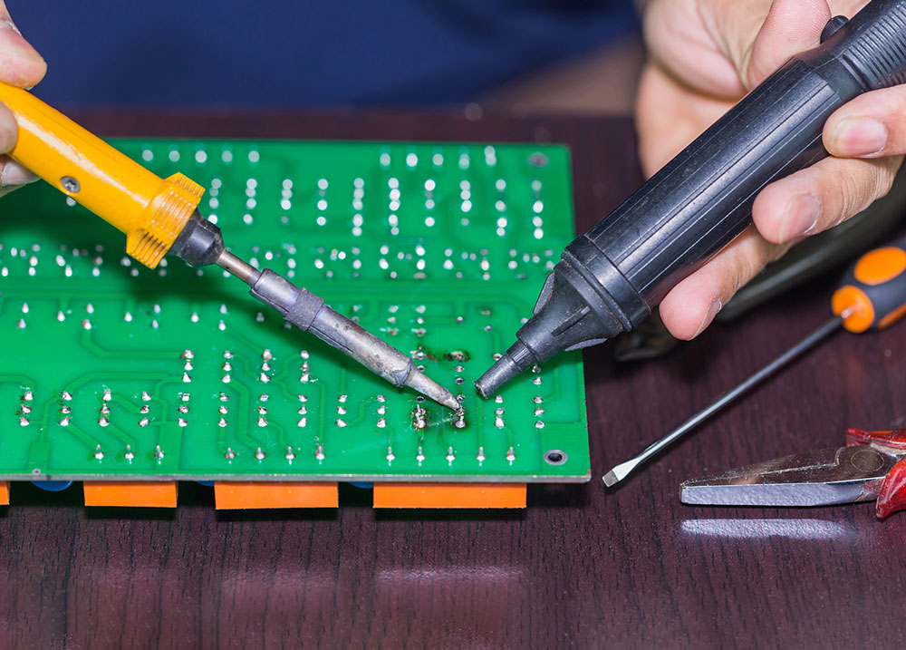 Man desoldering with the help of vacuum