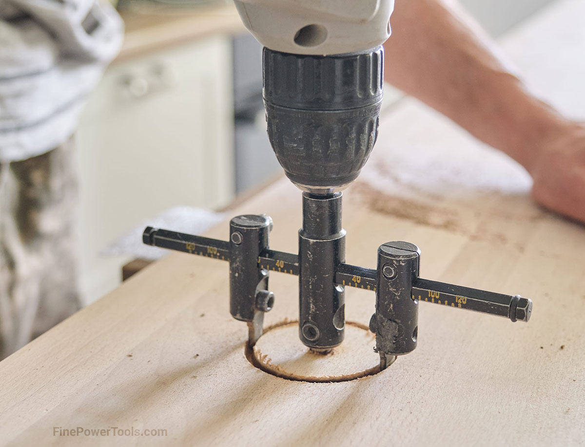 adjustable-circle-cutter Close-up of carpenters hand using adjustable circle cutter in wooden panel board.